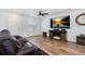 Inviting living room with hardwood floors, a ceiling fan, and a large flat-screen television at 10129 Glencoe Ct, Thornton, CO 80229