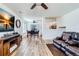 Cozy living room featuring wood floors, an entertainment center, and a view of the dining area at 10129 Glencoe Ct, Thornton, CO 80229