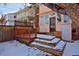 Inviting backyard featuring a multi-level deck, wooden fence, and an enclosed porch with large windows at 1586 Steele St, Denver, CO 80206