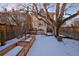 Expansive backyard with a wooden fence, raised garden beds and steps up to a charming porch at 1586 Steele St, Denver, CO 80206