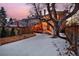 Backyard view featuring wooden fence, steps to a charming back porch, and an established shade tree, twilight at 1586 Steele St, Denver, CO 80206