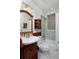 Traditional bathroom with wood vanity, glass block window and tiled shower/bath at 1586 Steele St, Denver, CO 80206