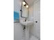 Stylish bathroom with a pedestal sink, black faucet and mirror frame, complemented by black and white floor tiles at 1586 Steele St, Denver, CO 80206