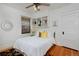 Cozy bedroom features a bed with white bedding, a ceiling fan, and built-in shelving above the bed at 1586 Steele St, Denver, CO 80206