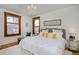 Bright bedroom with white walls, plush bedding, and stained glass window details at 1586 Steele St, Denver, CO 80206