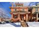 Brick home with covered front porch, steps and seasonal landscaping on a sunny winter day at 1586 Steele St, Denver, CO 80206