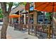 Charming restaurant exterior with outdoor seating, orange umbrellas, and large glass windows at 1586 Steele St, Denver, CO 80206