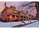 Brick homes line a snow-covered street, showcasing classic architecture and inviting front porches at 1586 Steele St, Denver, CO 80206