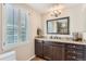 Well-lit bathroom with granite countertops, dark cabinets, and plantation shutters at 6731 S Kearney Ct, Centennial, CO 80112