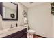 Half bathroom with hardwood floors, decorative mirror, and towel rack in a well-lit area at 6731 S Kearney Ct, Centennial, CO 80112