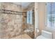 Elegant bathroom featuring a glass shower with decorative tile accents and natural lighting at 6731 S Kearney Ct, Centennial, CO 80112