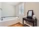 Modern bathroom with a soaking tub, plantation shutters, and vanity table at 6731 S Kearney Ct, Centennial, CO 80112