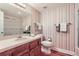 Bathroom featuring a vanity, sink, toilet, mirror, and striped wallpaper, blending comfort and style at 6731 S Kearney Ct, Centennial, CO 80112