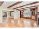 Spacious living room with hardwood floors, exposed wood beams, and custom built-in shelving at 6731 S Kearney Ct, Centennial, CO 80112
