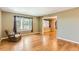 Cozy living room with hardwood floors, a large window with decorative curtains, and a comfortable armchair at 6731 S Kearney Ct, Centennial, CO 80112