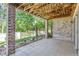 Under-deck patio with stone columns, landscaped surroundings, and ambient lighting at 6731 S Kearney Ct, Centennial, CO 80112