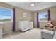 Bright bedroom with mountain views, a white crib, and purple accents at 2549 Loon Cir, Castle Rock, CO 80104
