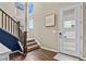 Inviting entryway with a three-paneled door, hardwood floors, and a staircase with a dark wood banister at 2549 Loon Cir, Castle Rock, CO 80104