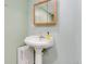 Classic bathroom with pedestal sink, wooden mirror, and neutral wall color for a clean, timeless aesthetic at 15104 E Utah Pl, Aurora, CO 80012