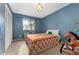 Bedroom with blue walls, a colorful bedspread, and natural light from the window at 15104 E Utah Pl, Aurora, CO 80012