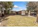 Exterior of home with a lush lawn and mature trees framing the brick facade, highlighting the two-car garage at 15104 E Utah Pl, Aurora, CO 80012