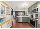 Modern kitchen featuring stainless steel appliances, olive green cabinets, and an open floor plan at 15104 E Utah Pl, Aurora, CO 80012