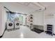 Bright laundry room with modern appliances, white walls, and practical storage solutions for easy organization at 15104 E Utah Pl, Aurora, CO 80012