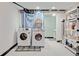 Laundry room featuring a modern washer and dryer, white painted walls, and tiled floors for easy maintenance at 15104 E Utah Pl, Aurora, CO 80012