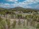 Aerial view of home nestled in a wooded area with mountain backdrop at 9288 Krashin Dr, Conifer, CO 80433