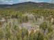 Overhead view of a secluded home surrounded by a dense forest, highlighting its privacy and access to nature trails at 9288 Krashin Dr, Conifer, CO 80433