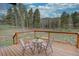 Relaxing outdoor deck featuring a small table and chairs, offering stunning views of the surrounding landscape at 9288 Krashin Dr, Conifer, CO 80433