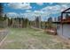 Backyard with a deck, tall trees, and a fenced yard at 9288 Krashin Dr, Conifer, CO 80433