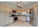 Well-lit kitchen featuring stainless steel appliances, light wood cabinets, dark countertops, and a stylish tile backsplash at 9288 Krashin Dr, Conifer, CO 80433