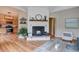 Inviting living room features a cozy fireplace, wood floors, and an open layout to the kitchen at 9288 Krashin Dr, Conifer, CO 80433