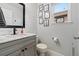 Bright half bathroom features a modern vanity, stylish mirror and charming beach-themed decor at 2805 Masters Ln, Castle Rock, CO 80104