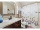 Cozy bathroom featuring a vanity, toilet, and a shower tub with a butterfly themed shower curtain at 2805 Masters Ln, Castle Rock, CO 80104