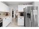 Bright kitchen featuring white cabinetry, stainless steel appliances, and a view to an eat-in dining area at 2805 Masters Ln, Castle Rock, CO 80104
