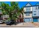 Attractive townhome with colorful facade, red garage door, and a tree in front at 12043 E Ford Cir, Aurora, CO 80012