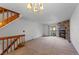 Bright living room featuring a stone fireplace, carpeted floor, and a wooden staircase at 12043 E Ford Cir, Aurora, CO 80012