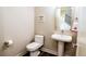 Half bath featuring a modern pedestal sink, wood floors, and a charming decorative sign at 15878 E Broncos Pl, Englewood, CO 80112