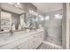 Elegant bathroom featuring double vanity, marble countertops, glass shower, and modern fixtures at 15878 E Broncos Pl, Englewood, CO 80112