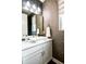 Modern half bath with vessel sink, decorative wallpaper, and tiled accent wall at 15878 E Broncos Pl, Englewood, CO 80112