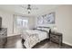 Relaxing bedroom featuring a ceiling fan, large window, and stylish decor at 15878 E Broncos Pl, Englewood, CO 80112