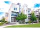 Stunning three-story townhome featuring modern architecture and a well-maintained front yard and small patio at 15878 E Broncos Pl, Englewood, CO 80112