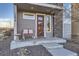 Welcoming front porch with seating and a decorative glass front door at 15878 E Broncos Pl, Englewood, CO 80112