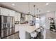 Modern kitchen boasts stainless steel appliances, a large island with seating, and stylish backsplash at 15878 E Broncos Pl, Englewood, CO 80112