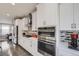 Well-equipped kitchen featuring stainless steel appliances, white cabinets, and stylish tile backsplash at 15878 E Broncos Pl, Englewood, CO 80112