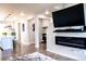 Open-concept living area with stylish fireplace and hardwood floors; kitchen in background at 15878 E Broncos Pl, Englewood, CO 80112