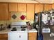 Kitchen with stove, refrigerator, and wood cabinets at 3953 Vrain St, Denver, CO 80212