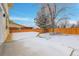 A winter backyard, complete with a wooden fence, snow, and a deck, offers a private outdoor space at 8694 E Eastman Ave, Denver, CO 80231